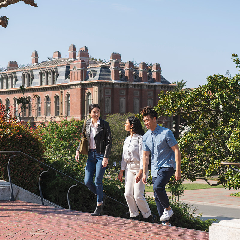 3 friends walking up brick stairs